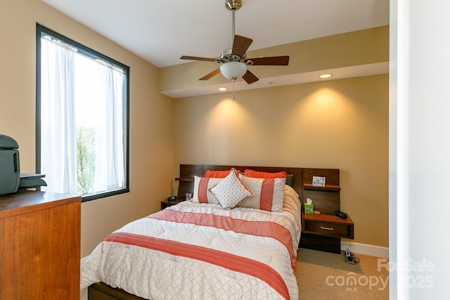 carpeted bedroom with ceiling fan and multiple windows