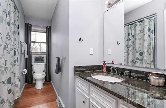 bathroom with hardwood / wood-style flooring, vanity, and toilet