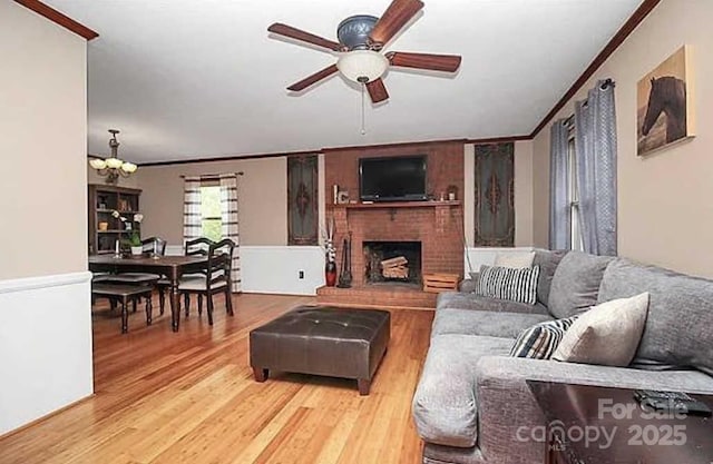 living room with crown molding, a fireplace, and light wood-type flooring