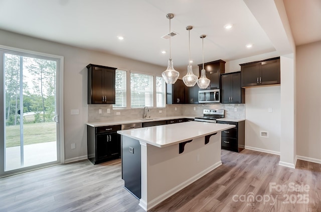 kitchen featuring pendant lighting, a center island, sink, plenty of natural light, and stainless steel appliances