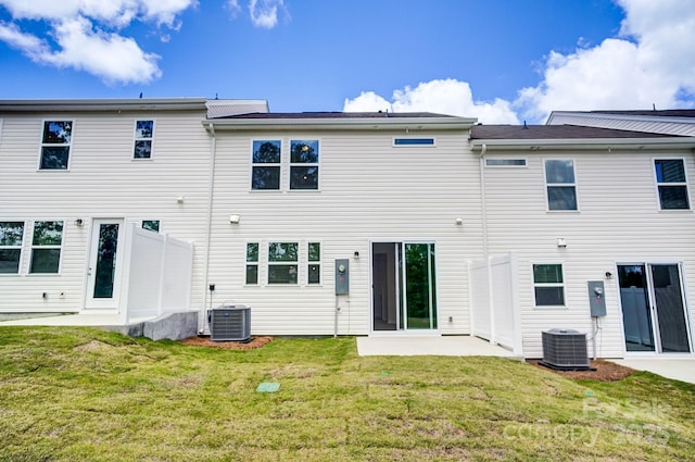 rear view of property with a patio, cooling unit, and a lawn