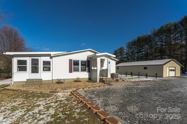 view of front of house with an outbuilding, a garage, and central AC unit