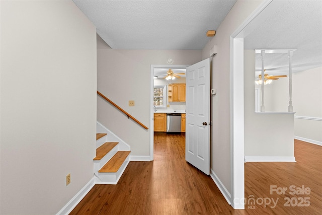 corridor with light hardwood / wood-style floors and a textured ceiling