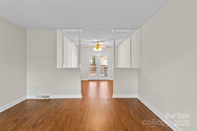 empty room with hardwood / wood-style floors, french doors, and ceiling fan