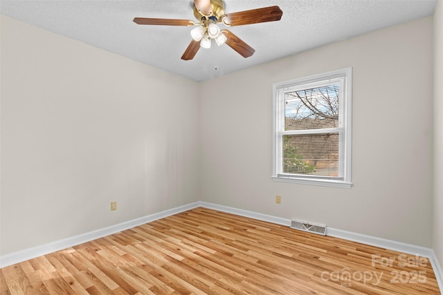 spare room featuring light wood-type flooring, a textured ceiling, and ceiling fan