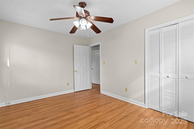 unfurnished bedroom with light hardwood / wood-style floors, a closet, and ceiling fan