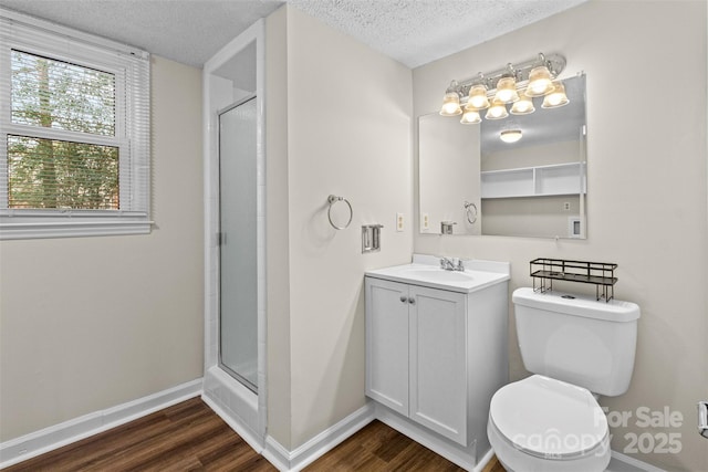 bathroom with a textured ceiling, toilet, hardwood / wood-style floors, and an enclosed shower