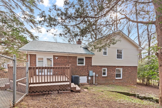 back of property with central AC unit and a wooden deck