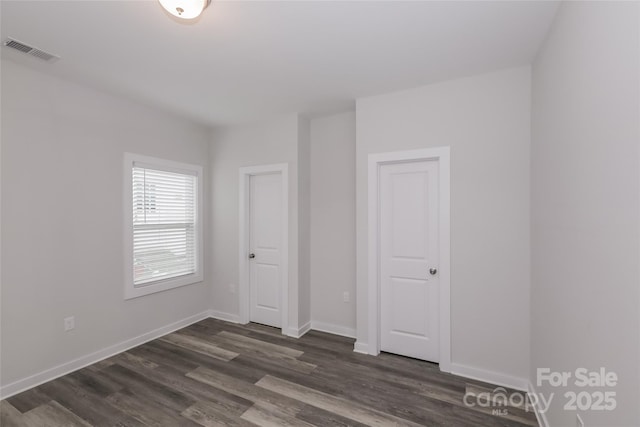 unfurnished bedroom with dark wood-type flooring