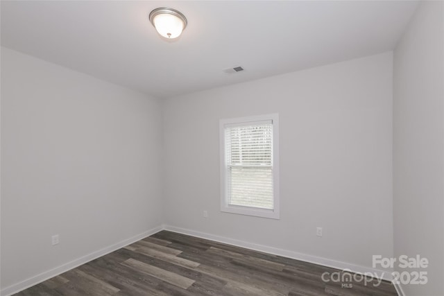 spare room with dark hardwood / wood-style flooring