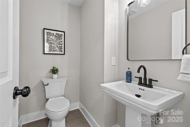 bathroom with hardwood / wood-style flooring, sink, and toilet