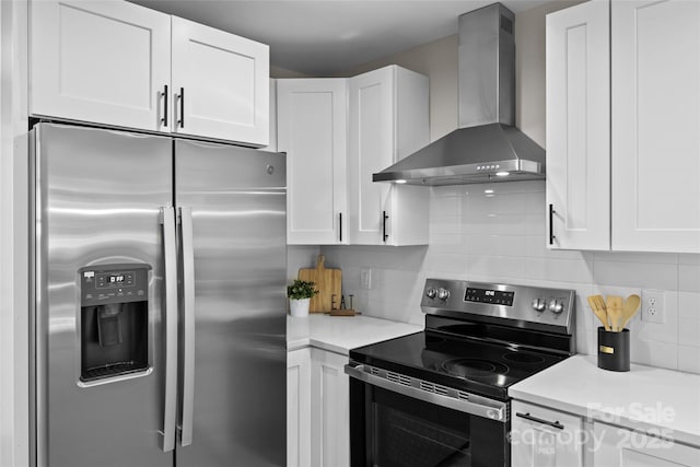 kitchen with tasteful backsplash, white cabinets, stainless steel appliances, and wall chimney exhaust hood