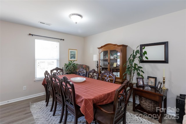 dining space with wood-type flooring