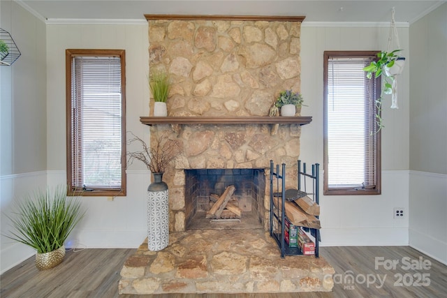 living room featuring wood-type flooring, ornamental molding, and a wealth of natural light