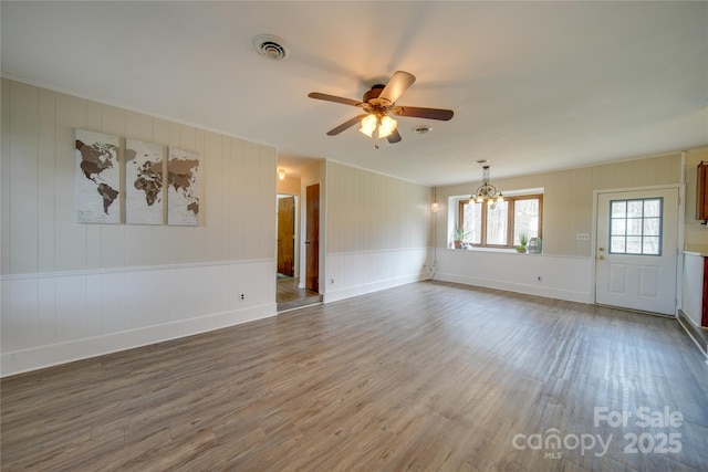 unfurnished room with ceiling fan with notable chandelier and dark hardwood / wood-style floors