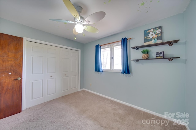 unfurnished bedroom with light carpet, a closet, and ceiling fan