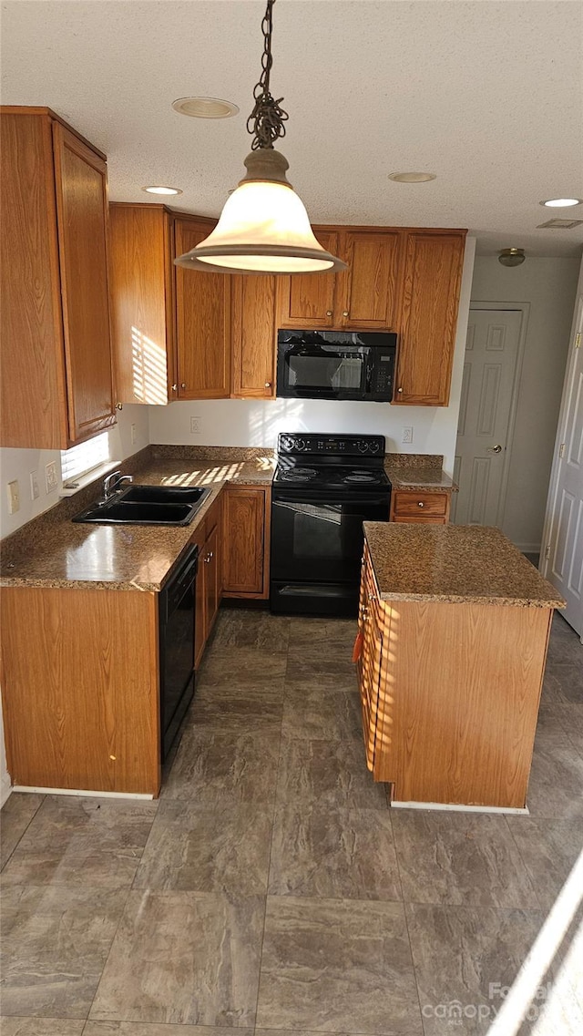 kitchen with black appliances, decorative light fixtures, a kitchen island, and sink