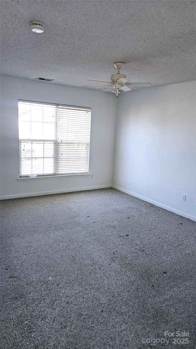 spare room featuring carpet, a textured ceiling, and ceiling fan