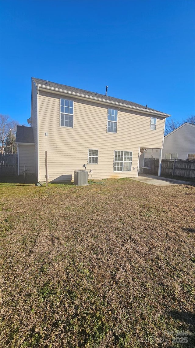 back of house featuring central AC unit, a yard, and a patio