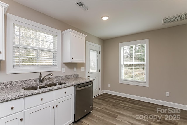 kitchen with white cabinets, light stone countertops, dishwasher, and sink