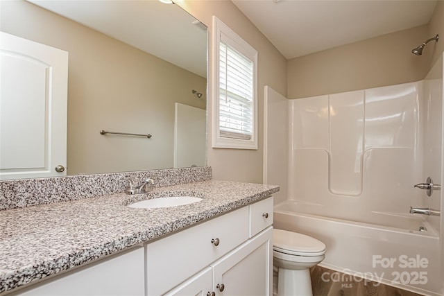 full bathroom featuring toilet, washtub / shower combination, and vanity