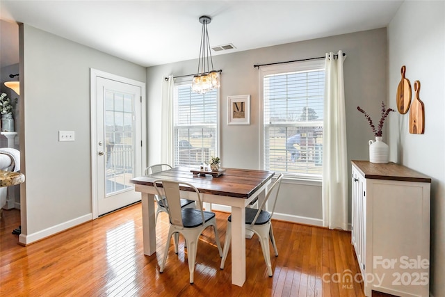 dining area featuring light wood-type flooring and a chandelier