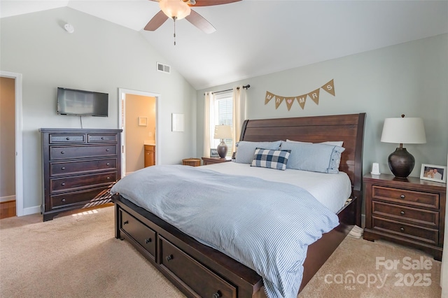 carpeted bedroom with ensuite bathroom, vaulted ceiling, and ceiling fan