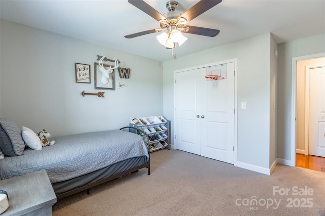 carpeted bedroom with ceiling fan and a closet