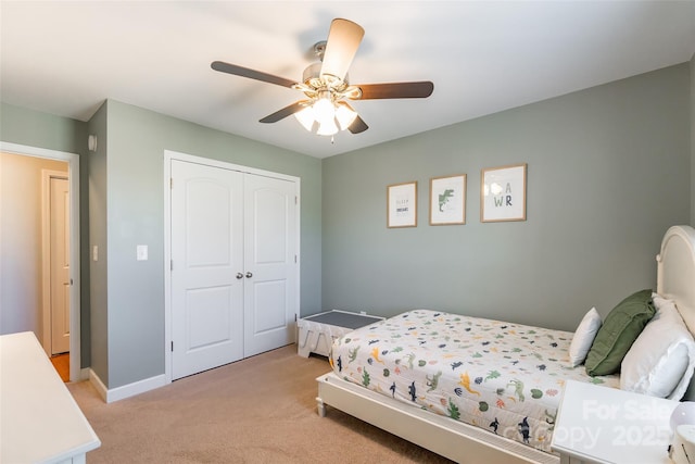 bedroom with ceiling fan, a closet, and light carpet