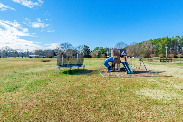 view of jungle gym with a lawn and a trampoline