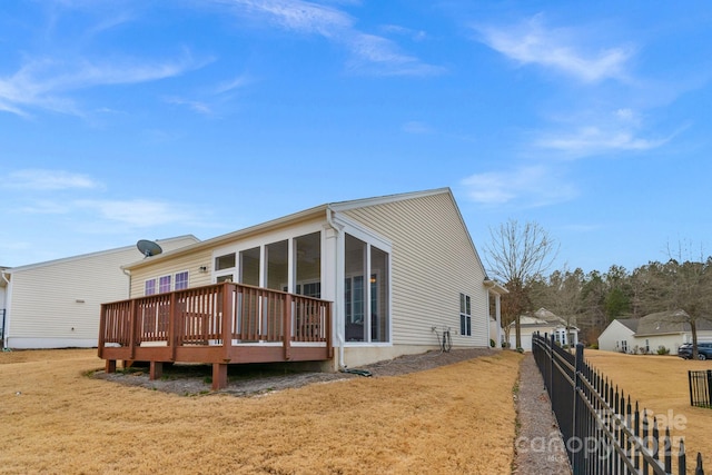 back of house with a yard, a sunroom, and a deck