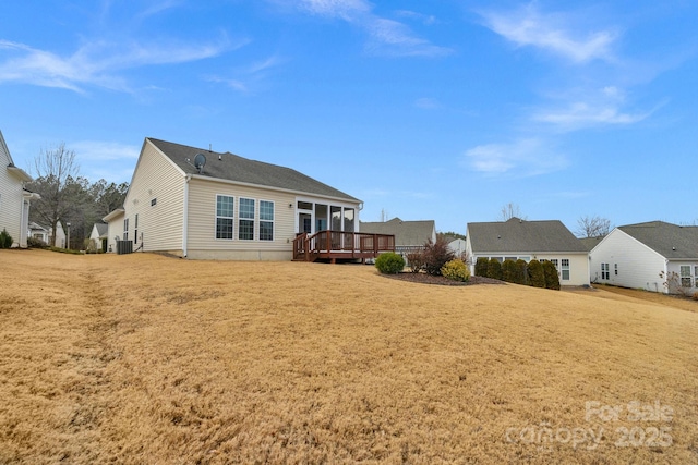 rear view of house featuring a wooden deck, a yard, and central AC