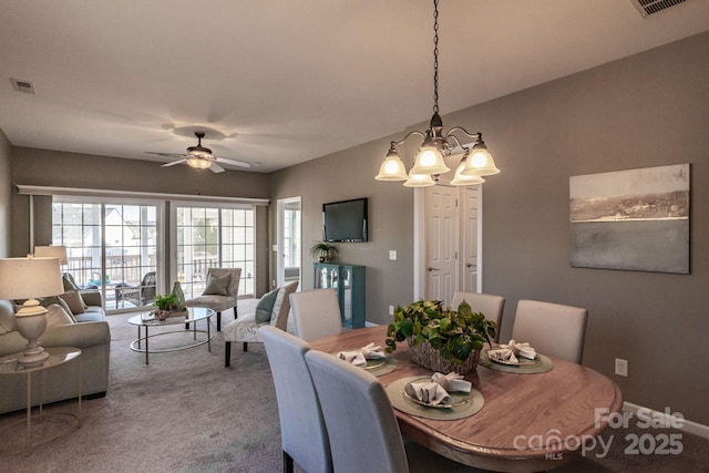 carpeted dining room featuring ceiling fan with notable chandelier