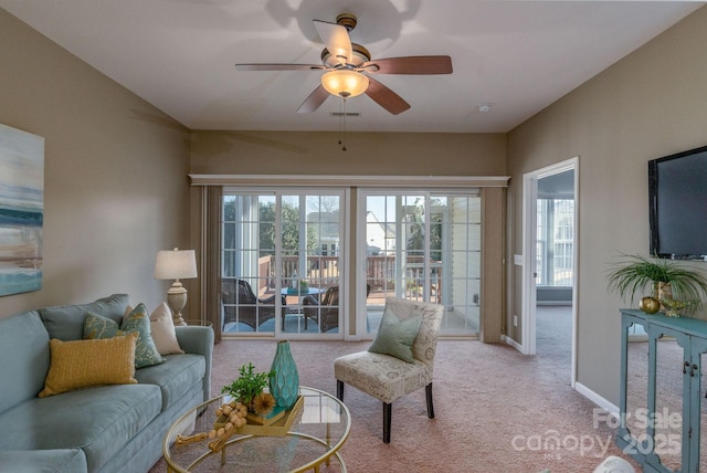 carpeted living room featuring plenty of natural light and ceiling fan