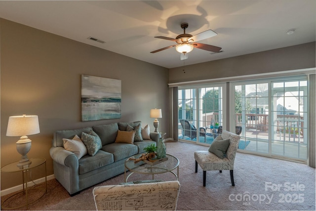 carpeted living room with a wealth of natural light and ceiling fan