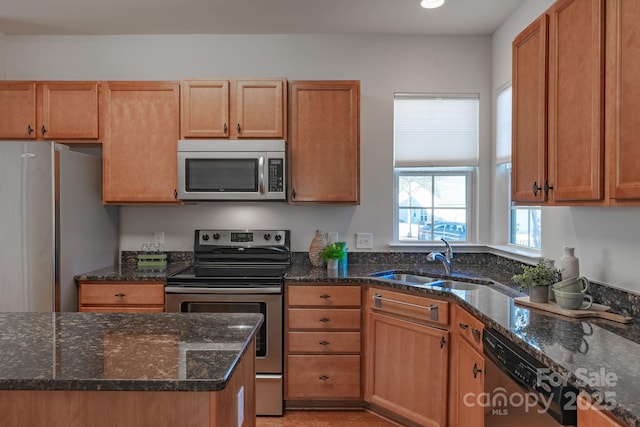 kitchen featuring stainless steel appliances, sink, and dark stone counters