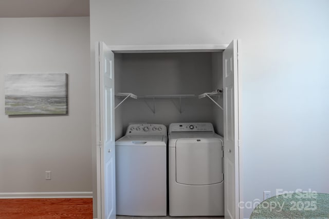 laundry room with hardwood / wood-style flooring and washer and dryer