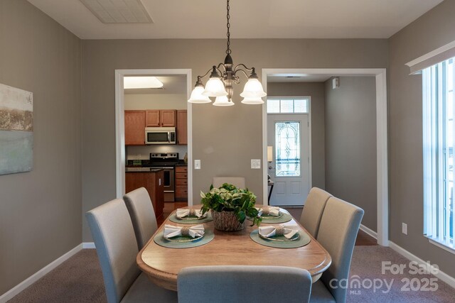 dining area featuring a notable chandelier and carpet