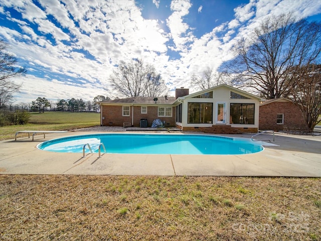 view of swimming pool featuring a diving board, a patio area, and a yard