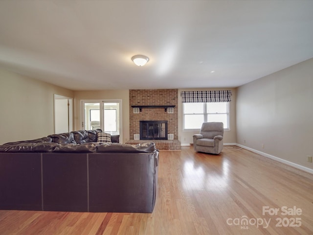 living room featuring light hardwood / wood-style floors, plenty of natural light, and a fireplace