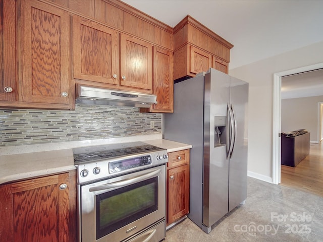 kitchen with light stone countertops, stainless steel appliances, and tasteful backsplash