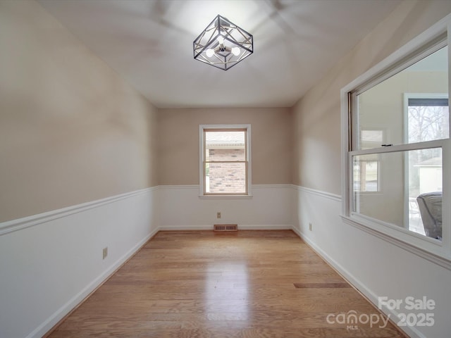 unfurnished room with a healthy amount of sunlight and light hardwood / wood-style floors