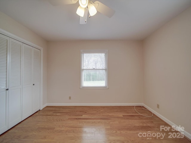 unfurnished bedroom featuring ceiling fan, a closet, and light wood-type flooring