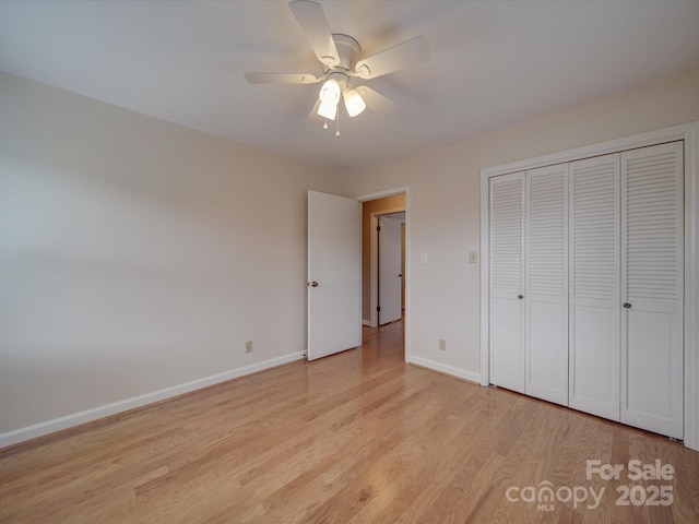 unfurnished bedroom featuring ceiling fan, a closet, and light wood-type flooring