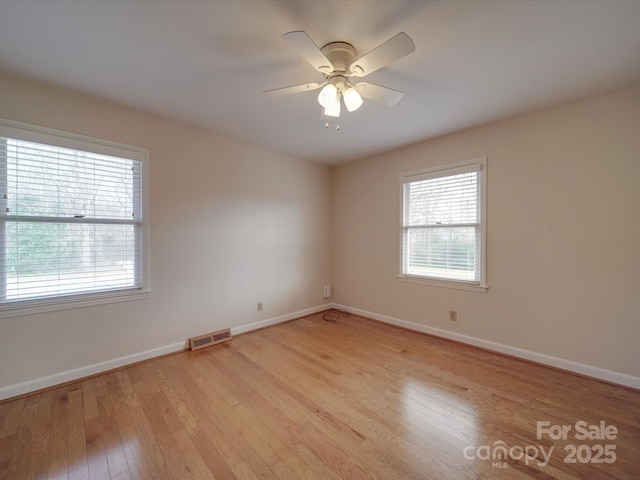 spare room with ceiling fan and light wood-type flooring