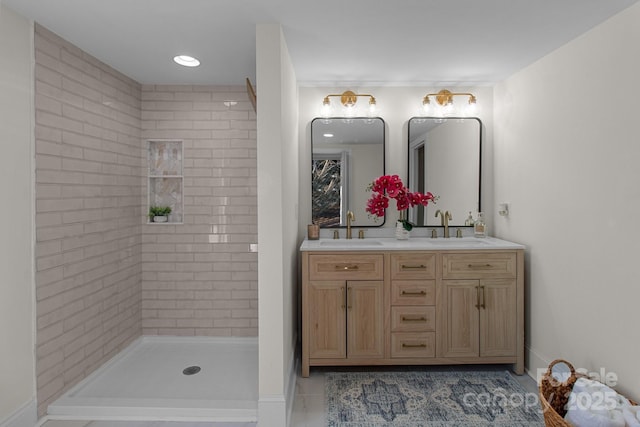 bathroom featuring tile patterned floors, tiled shower, and vanity