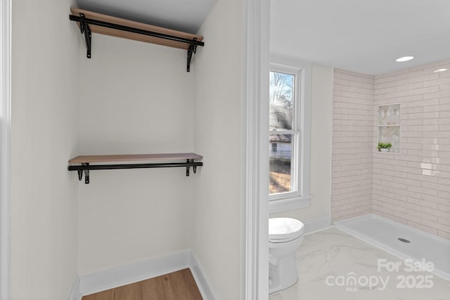 bathroom featuring toilet and tiled shower