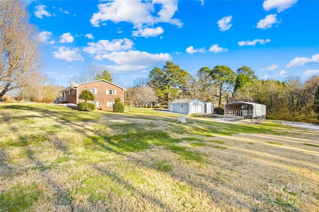 view of yard featuring a garage, a carport, and an outbuilding