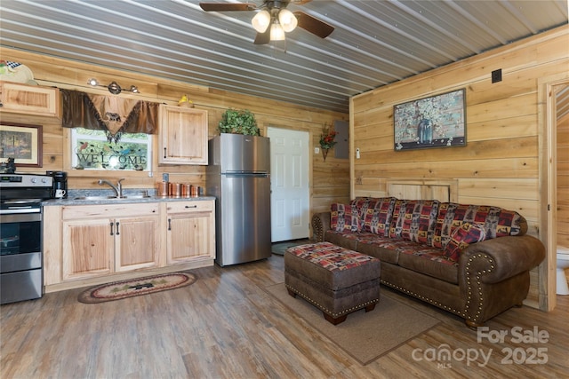 living room featuring ceiling fan, wooden walls, dark hardwood / wood-style floors, and sink