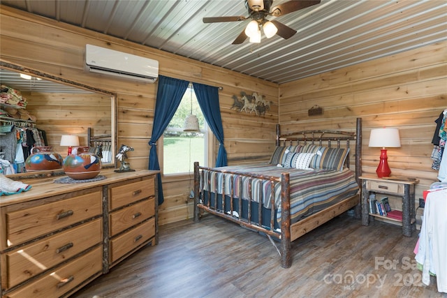 bedroom featuring dark wood-type flooring, a wall unit AC, ceiling fan, and wooden walls